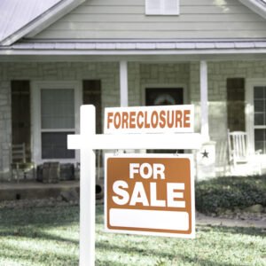 house with foreclosure sale sign in front